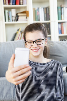 Porträt eines lächelnden Mädchens, das ein Selfie zu Hause macht - LVF08011