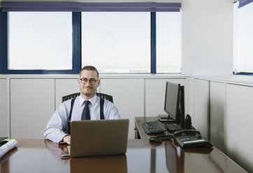 Porträt eines selbstbewussten Geschäftsmannes am Schreibtisch im Büro - AHSF00225