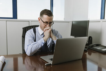 Businessman using laptop at desk in office - AHSF00226