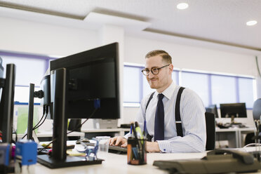 Geschäftsmann mit Computer am Schreibtisch im Büro - AHSF00229