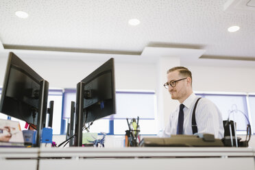 Geschäftsmann mit Computer am Schreibtisch im Büro - AHSF00230