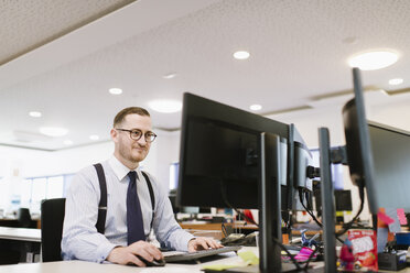 Geschäftsmann mit Computer am Schreibtisch im Büro - AHSF00231