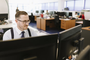 Geschäftsmann mit Computer am Schreibtisch im Büro - AHSF00233