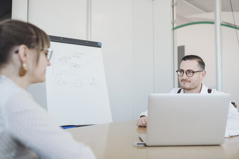 Geschäftsfrau und Geschäftsmann mit Laptop bei der Arbeit im Büro - AHSF00266