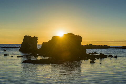 USA, Hawaii, Big Island, Sonnenuntergang über riesigen Felsen im Kikaua Point Park, lizenzfreies Stockfoto