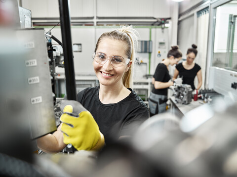 Drei Frauen arbeiten an Maschinen, lizenzfreies Stockfoto