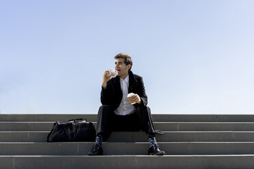 Geschäftsmann sitzt auf einer Treppe und macht Mittagspause - AFVF02837