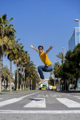 Spanien, Barcelona, Mann in der Stadt springt auf die Straße - AFVF02884