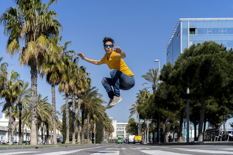 Spanien, Barcelona, Mann in der Stadt springt auf die Straße, lizenzfreies Stockfoto
