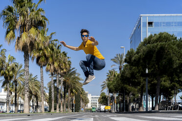 Spanien, Barcelona, Mann in der Stadt springt auf die Straße - AFVF02885