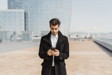 Businessman using cell phone in the city - AFVF02906