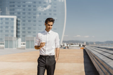 Portrait of businessman with takeaway coffee in the city - AFVF02916