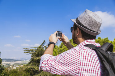 Italy, Le Marche, Loreto, mid adult tourist using action cam at viewpoint - FLMF00192