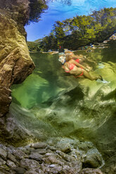 Österreich, Salzkammergut, junge Frau beim Schnorcheln im Gebirgsfluss Weissenbach - YRF00214