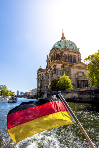 Deutschland, Berlin, Berliner Dom und deutsche Flagge auf Ausflugsschiff auf der Spree, lizenzfreies Stockfoto