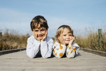 Porträt eines Jungen und seiner kleinen Schwester, die Seite an Seite auf der Promenade liegen - JRFF03192