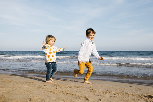 Junge und seine kleine Schwester spielen am Strand - JRFF03209