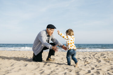 Grandfather playing with his granddaughter on the beach - JRFF03214