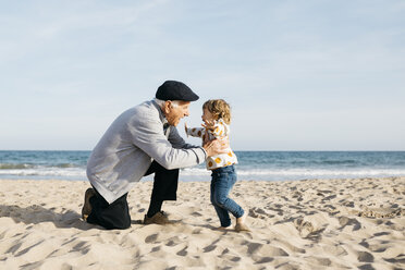 Grandfather playing with his granddaughter on the beach - JRFF03218