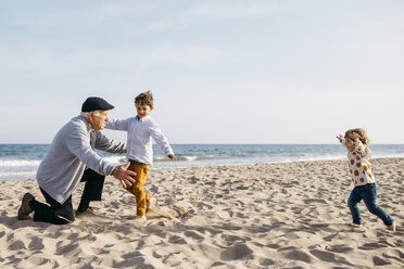 Grandfather playing with his grandchildren on the beach in spring - JRFF03222