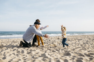 Großvater spielt mit seinen Enkelkindern am Strand im Frühling - JRFF03223