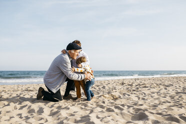 Großvater umarmt seine Enkelkinder am Strand im Frühling - JRFF03224