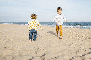 Boy and his little sister playing on the beach - JRFF03225