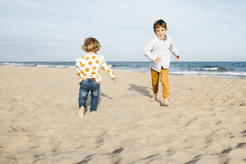Junge und seine kleine Schwester spielen am Strand - JRFF03225