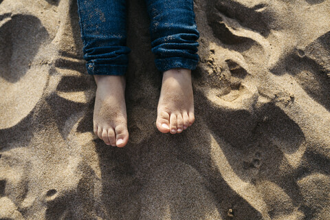 Füße eines kleinen Mädchens am Sandstrand, Nahaufnahme, lizenzfreies Stockfoto