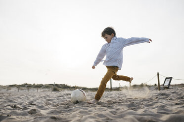 Kleiner Junge spielt Fußball am Strand und kickt den Ball - JRFF03236