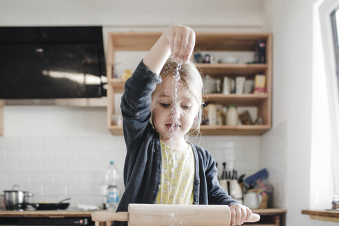 Little girl rolling out dough in the kitchen - KMKF00900