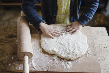 Girl's hands kneading dough, partial view - KMKF00902