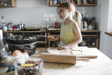 Little girl preparing stuffed pastry in the kitchen - KMKF00912