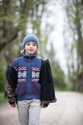 Portrait of young boy wearing blue hat and sweater in a park - EYAF00190