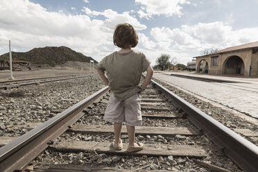 Caucasian boy standing with hands on hips on train track - BLEF02082