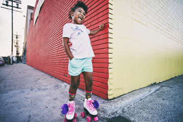 Black girl wearing roller skates on urban sidewalk - BLEF02120