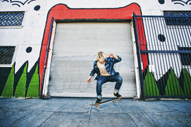 Caucasian man jumping on skateboard - BLEF02125