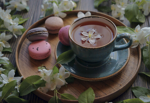 Blumen auf Tablett mit Tee und Makronen, lizenzfreies Stockfoto