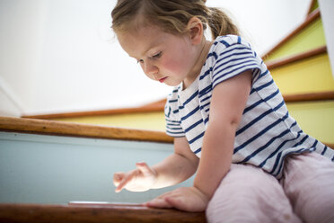 Kaukasisches Mädchen benutzt digitales Tablet auf einer Treppe - BLEF02176