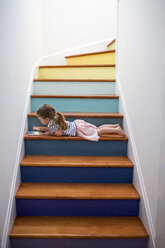 Caucasian girl using digital tablet on multicolor staircase - BLEF02177
