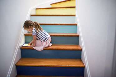 Kaukasisches Mädchen benutzt digitales Tablet auf einer mehrfarbigen Treppe - BLEF02178