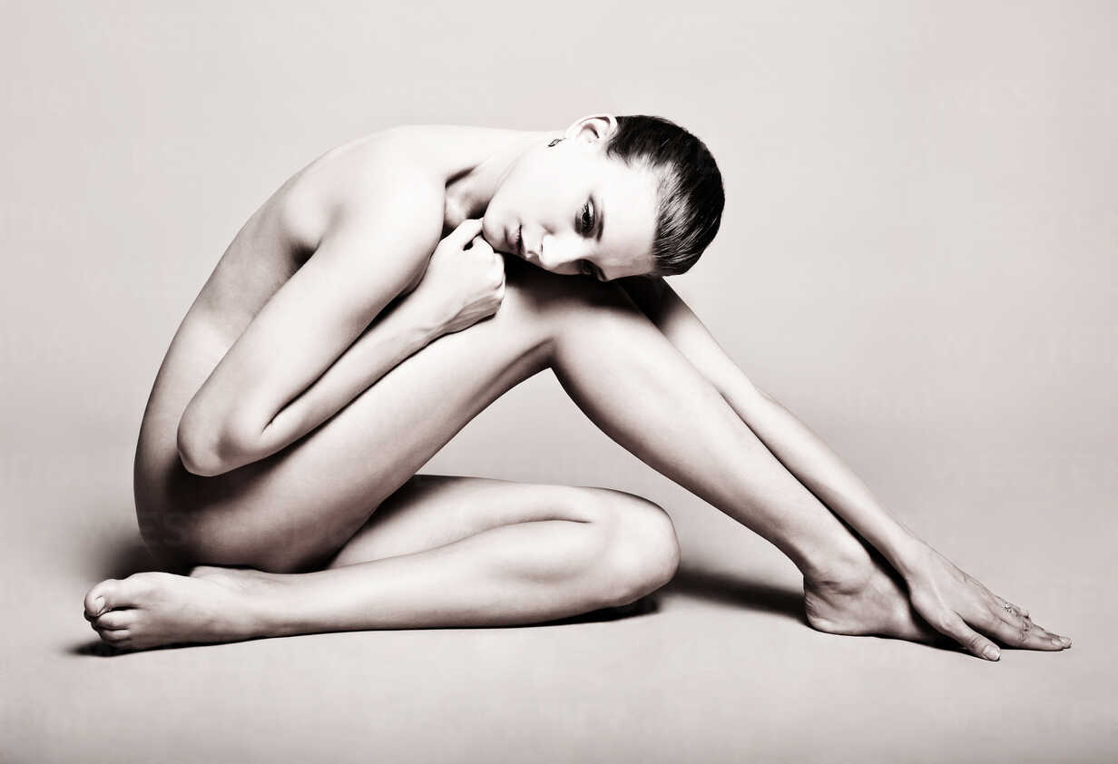 Portrait of naked woman sitting on floor Stock Photo - Alamy