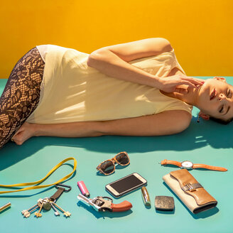 Caucasian woman laying on floor near wallet, gun and cell phone - BLEF02205