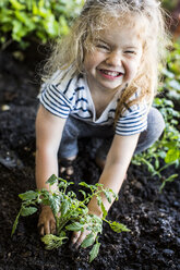 Caucasian girl posing with plant in garden - BLEF02240