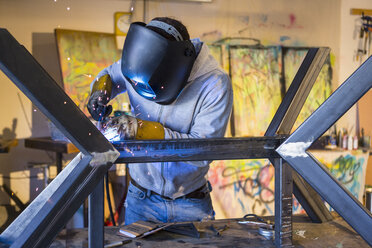 Caucasian man welding metal sculpture - BLEF02248