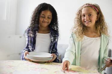 Girls setting the table for meal - BLEF02290