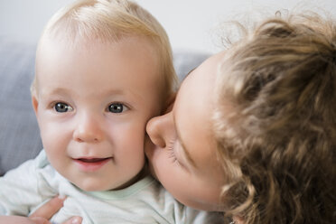 Smiling Caucasian girl kissing baby brother on cheek - BLEF02321