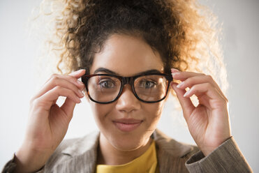 Mixed Race woman adjusting eyeglasses - BLEF02344