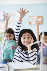 Mädchen lernen über Windmühlen und heben die Hände im Klassenzimmer - BLEF02380