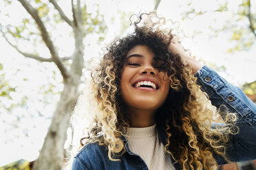 Smiling Mixed Race woman with hand in hair - BLEF02395